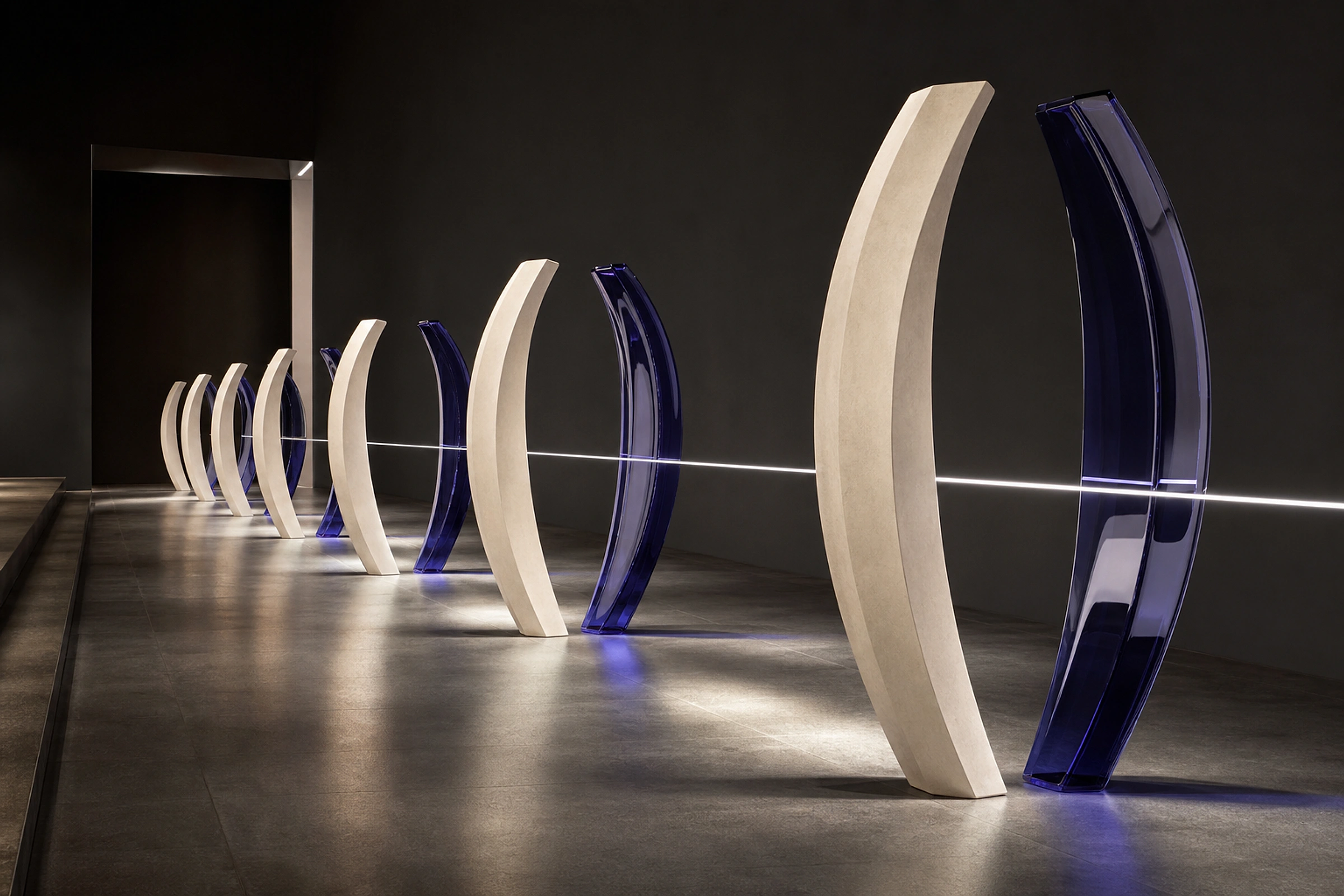 A field of paired sculptural forms connected by a precise line of light